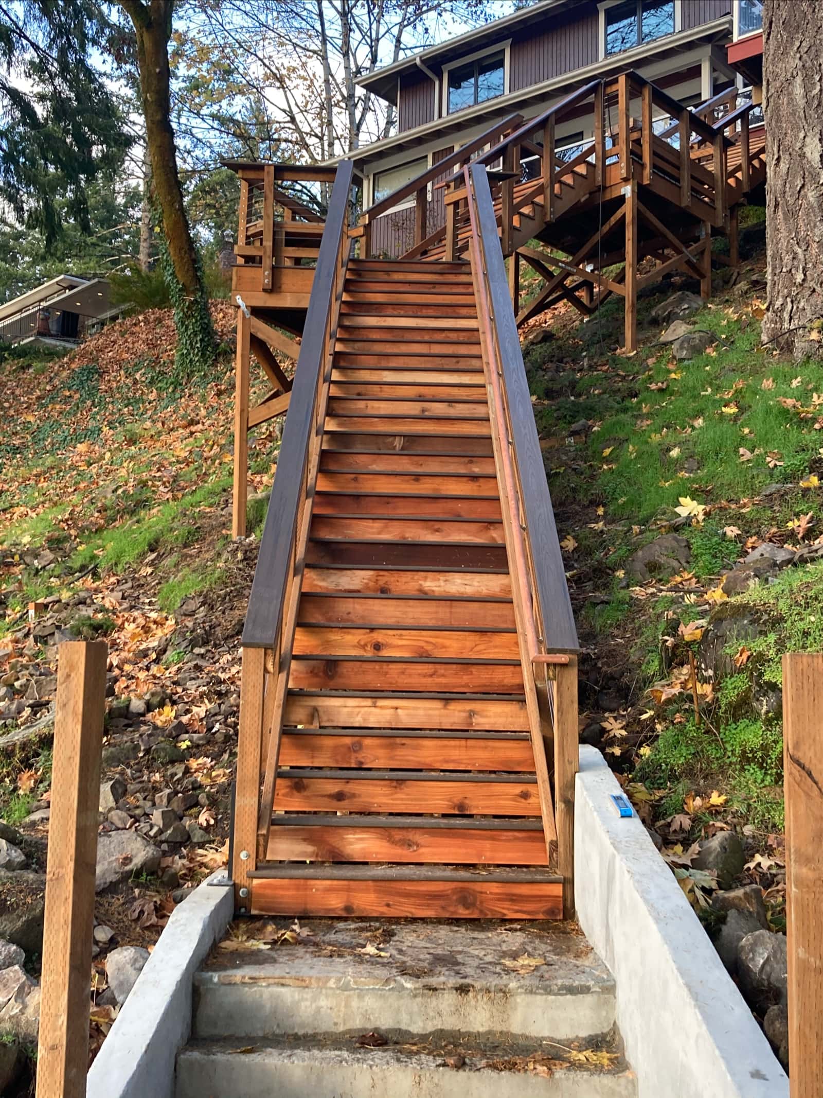 Outdoor hillside staircase with wood treads climbing a wooded Portland slope, built by Stumptown Stairs