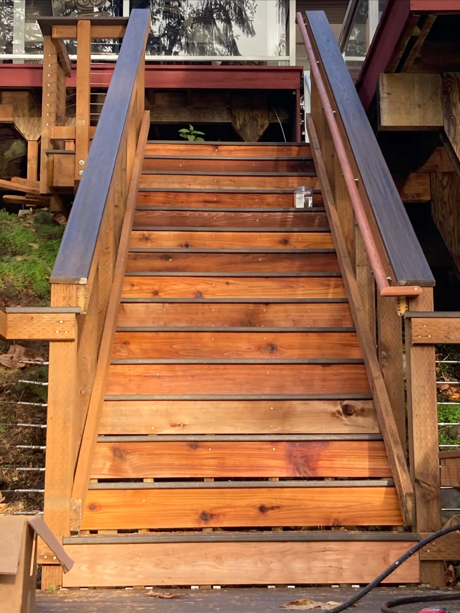 Wood-tone stairway with black metal accent railing — Stumptown Stairs, Portland, OR