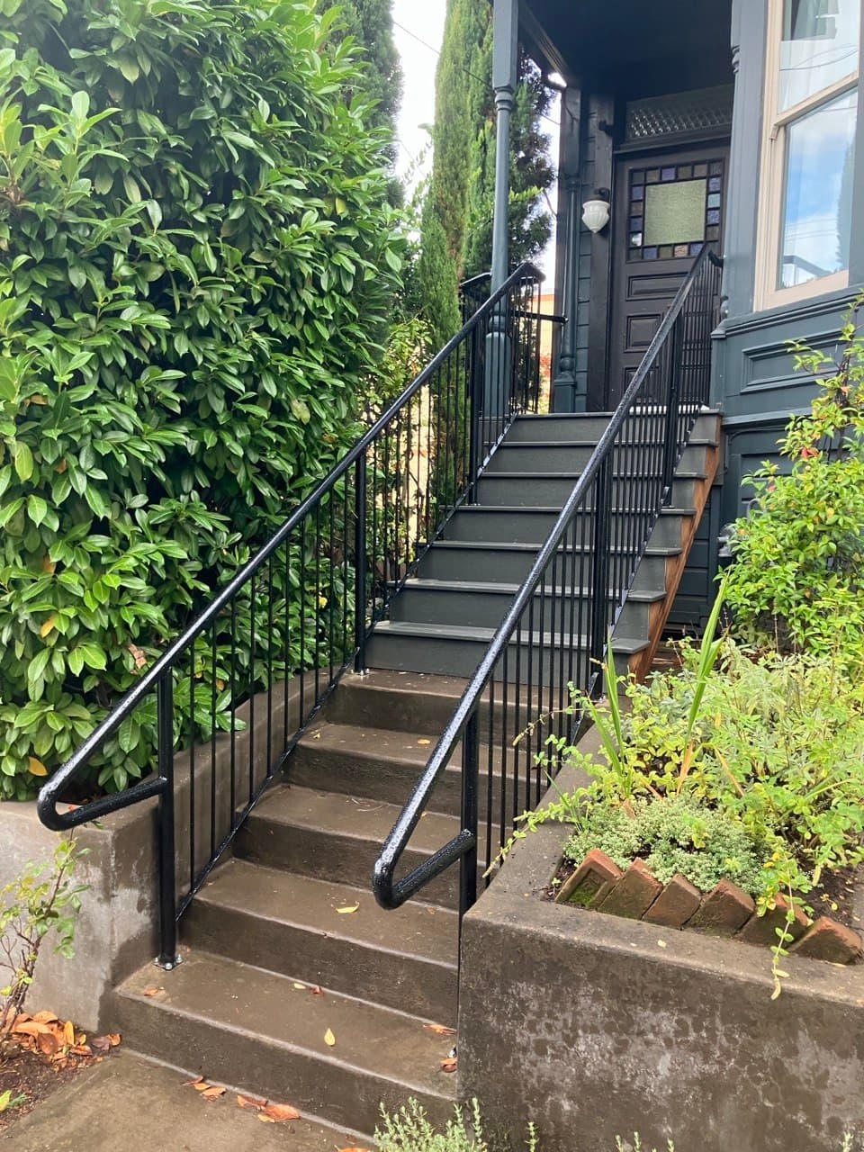 Welded black steel stair railings on a Victorian entry — Stumptown Stairs, Portland, OR