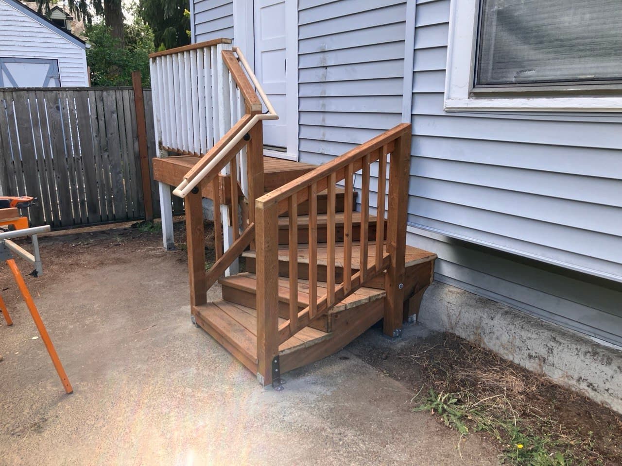 New exterior porch steps with wood railing, built by Stumptown Stairs in Portland