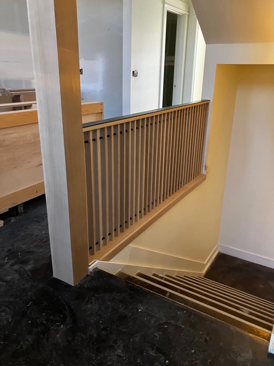 Slat guardrail installation in progress in an occupied building — phased commercial stair work by Stumptown Stairs, Portland, OR