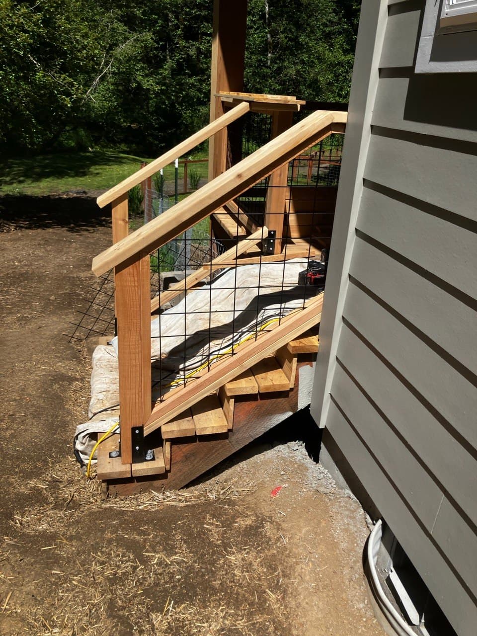 Cedar deck stairs with wire-mesh railing built by Stumptown Stairs in Portland
