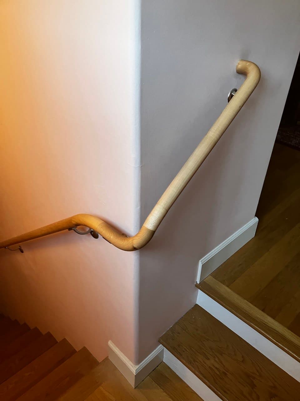 Wall-mounted wood handrail with curved returns installed in a Portland stairwell