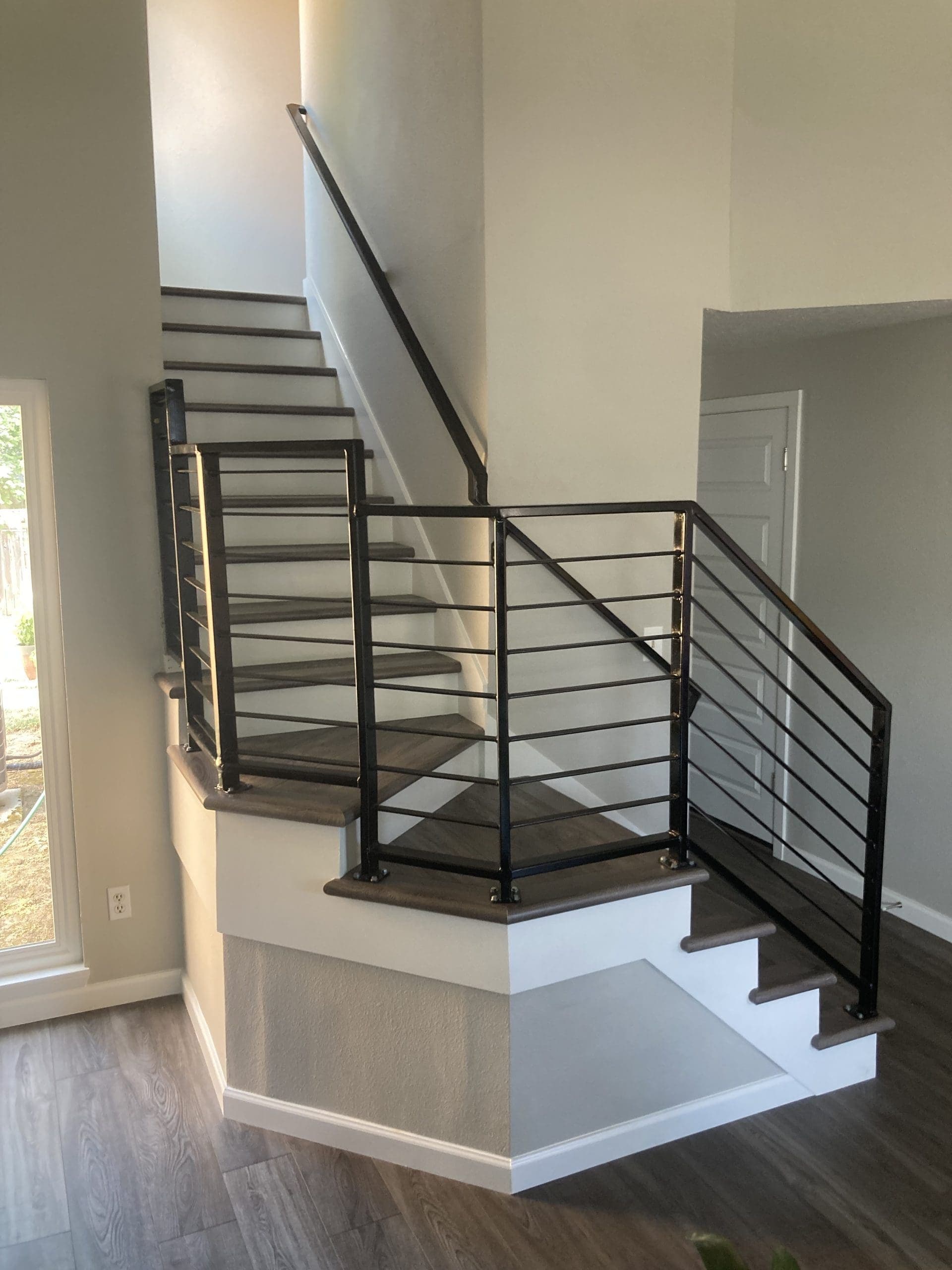Contemporary staircase with welded black steel horizontal railing in a newer Oregon City-area home