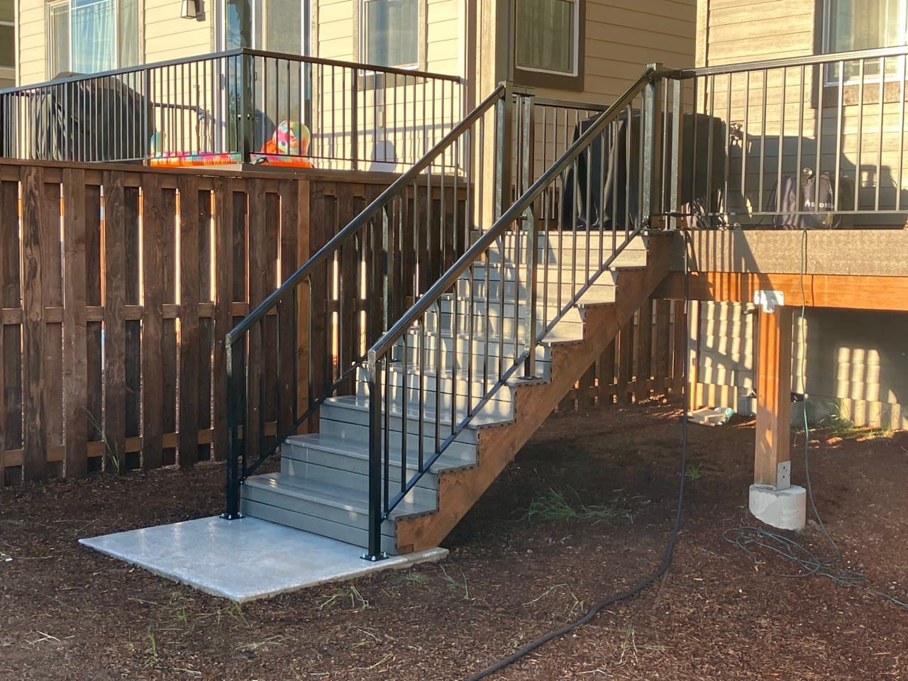 Finished exterior stairs with composite treads and welded black steel railing, Portland, OR