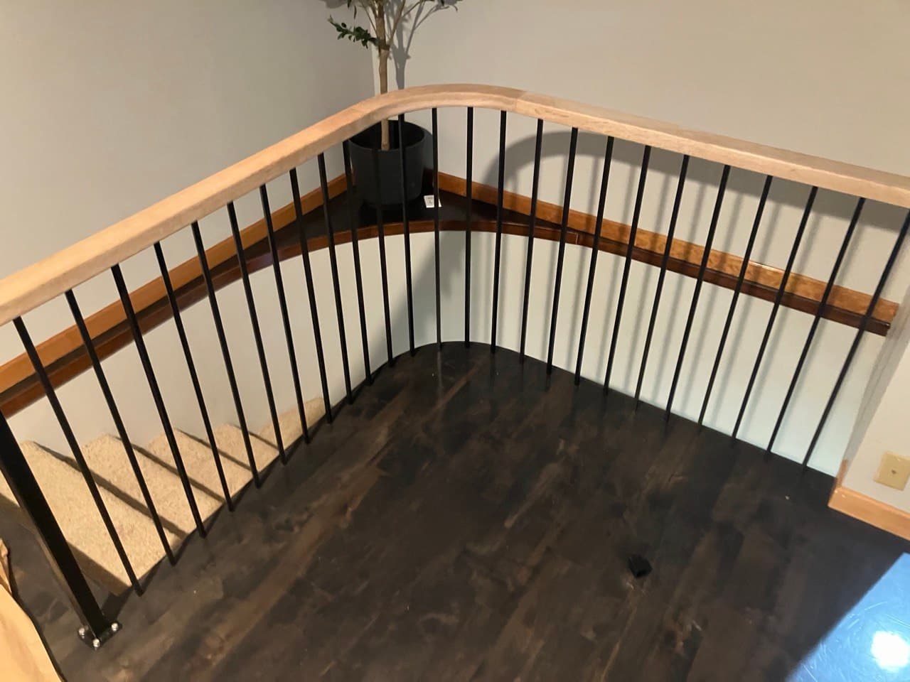 Curved guardrail with black balusters and wood cap rail, Portland loft