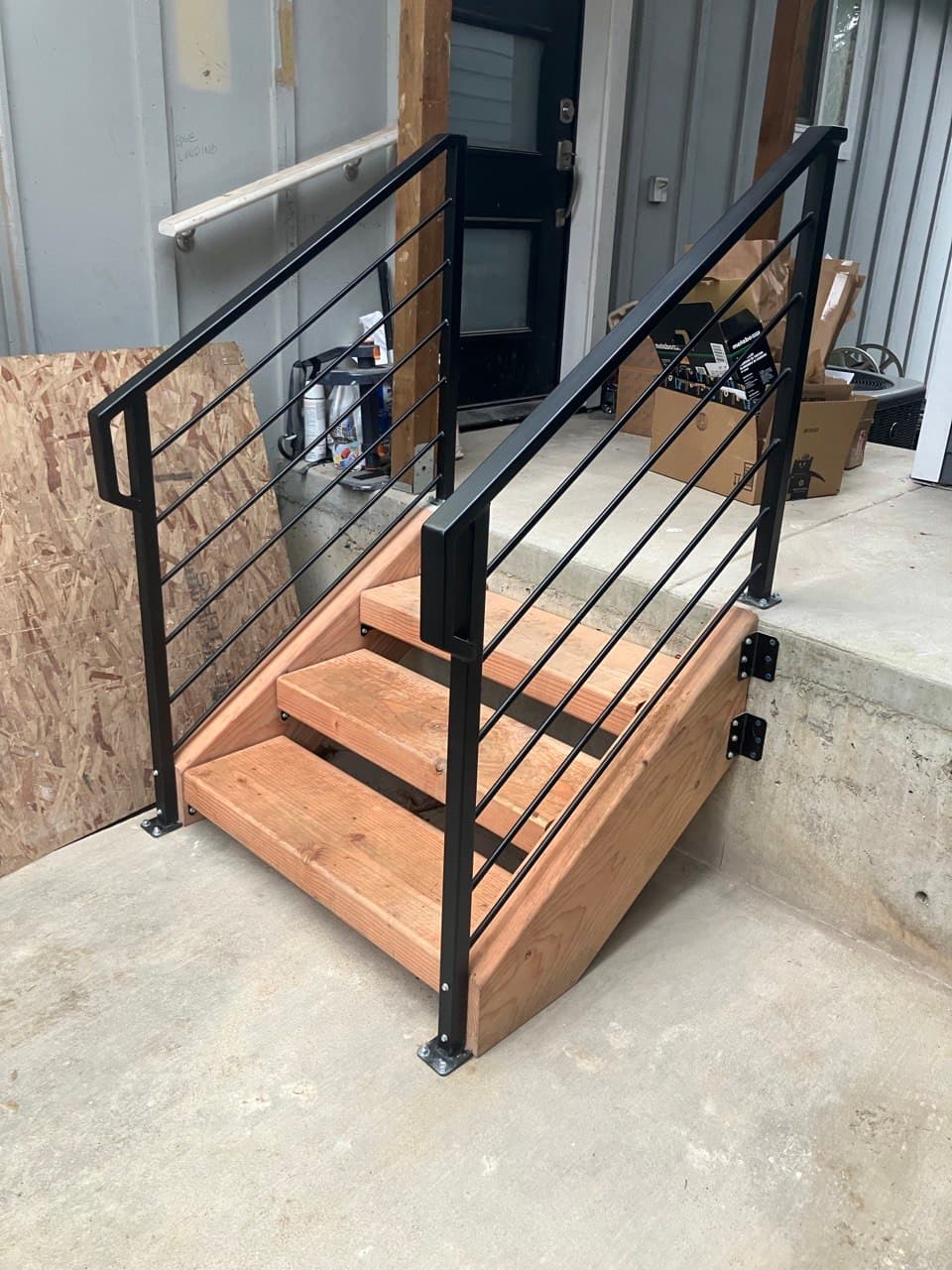Compact commercial entry stairs with fir treads and welded black steel bar railings, Portland, OR
