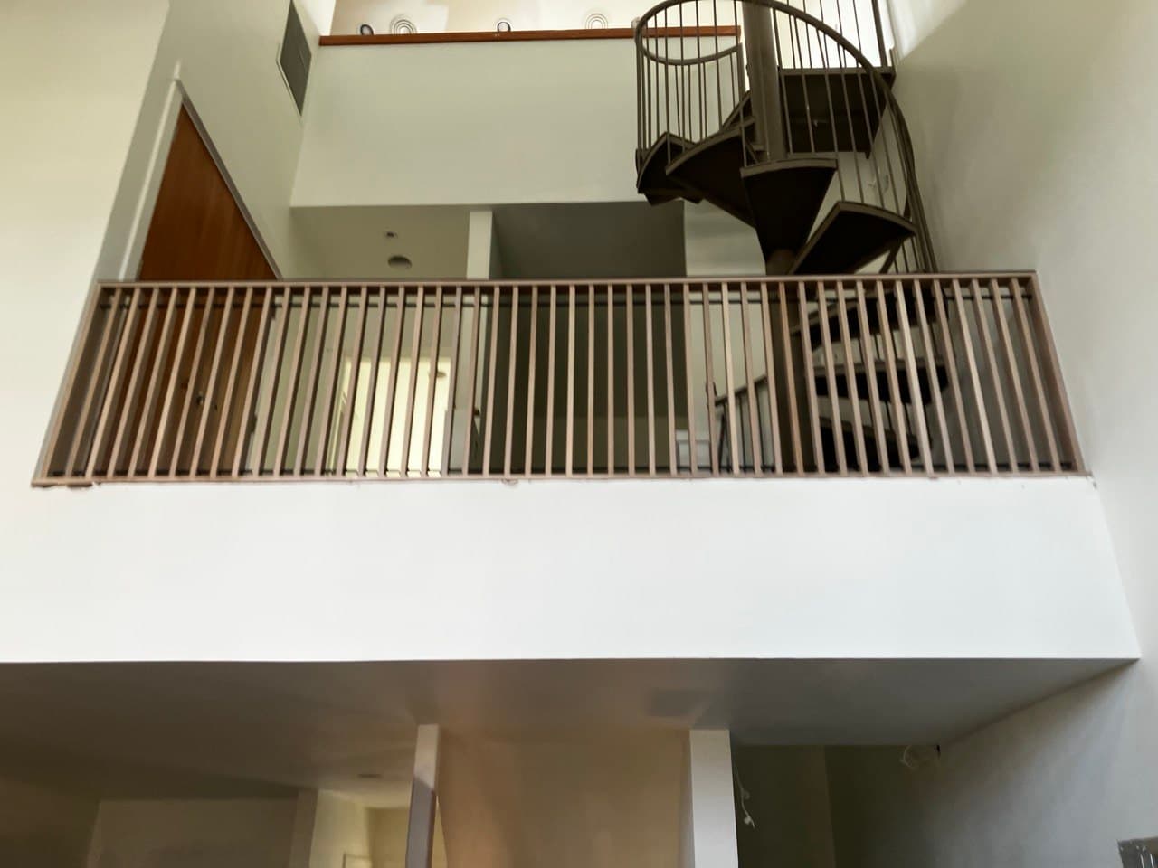 Multi-level commercial space with steel spiral staircase and continuous balcony guardrail — Stumptown Stairs, Portland, OR