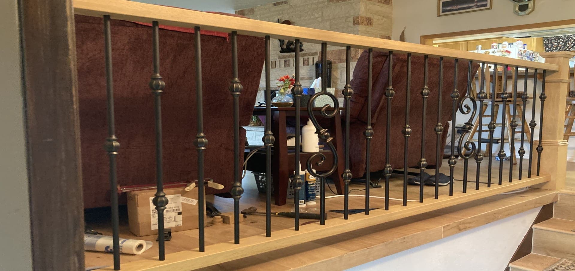 Interior railing with ornate wrought-iron balusters and wood cap rail — Stumptown Stairs, Portland, OR