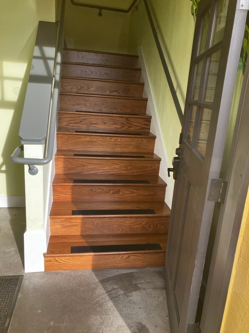 Repaired staircase with refinished oak treads and new traction strips, Portland, OR
