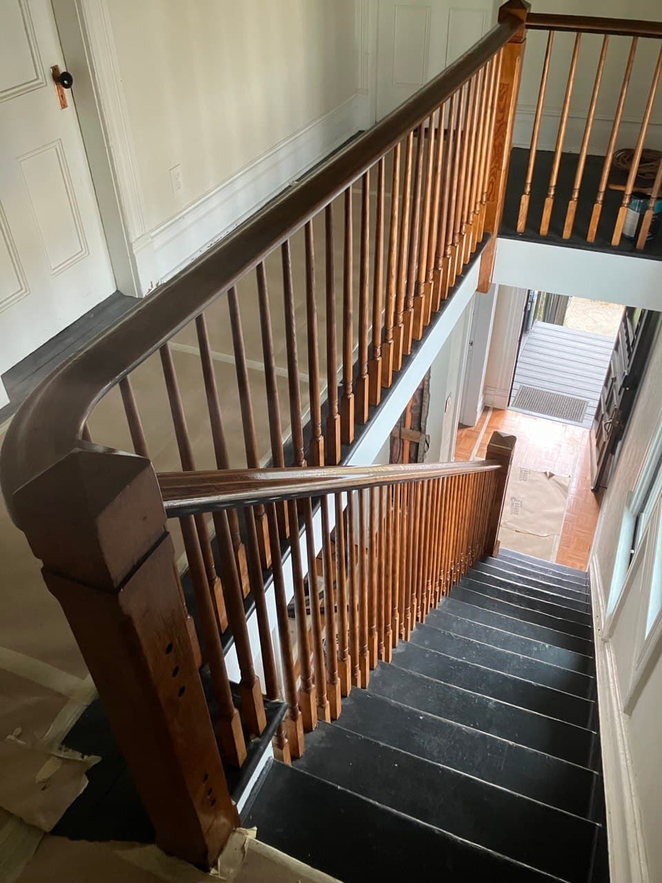 Restored historic staircase with refinished turned balusters and dark-painted treads — stair repair by Stumptown Stairs, Portland, OR